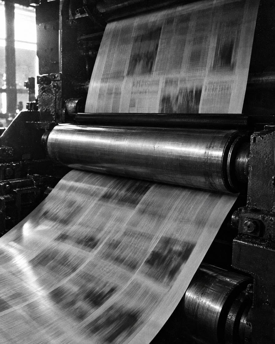 Newspapers running through a printing press